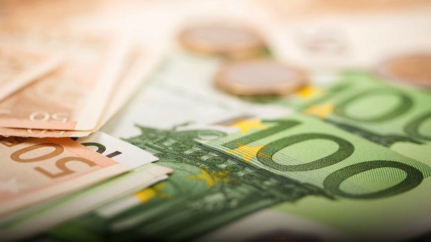 Mehrere Geldscheine und -münzen in Eurowährung.