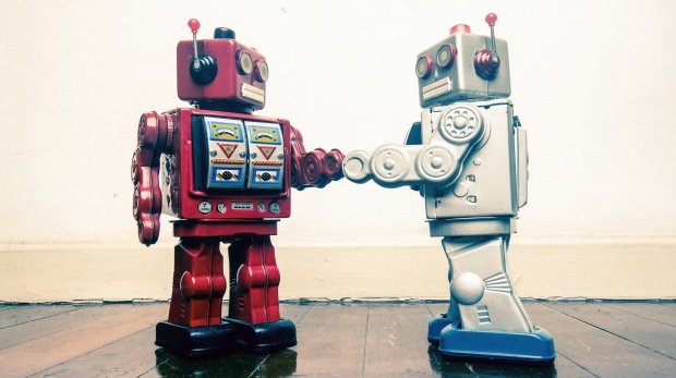 Zwei Vintage-Roboter schütteln sich die Hände