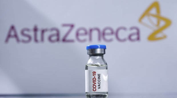 Eine Impfdose vor dem Astrazeneca Logo