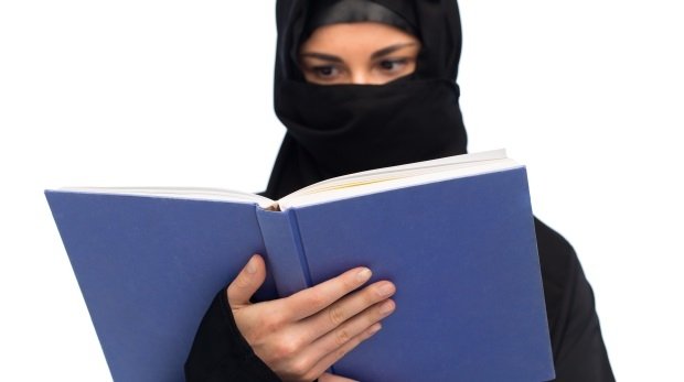 Verschleierte Frau liest ein Buch (Symbolbild)