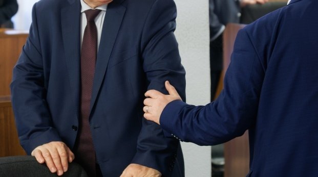 Zwei Männer im Anzug begrüßen sich vor einem Meeting