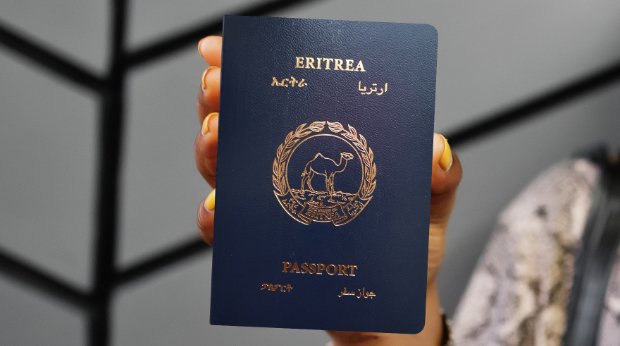Eine Person hält einen Reisepass von Eritrea in der Hand