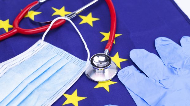 Mund-Nasen-Schutz, Stethoskop, Handschuhe auf Flagge der EU.