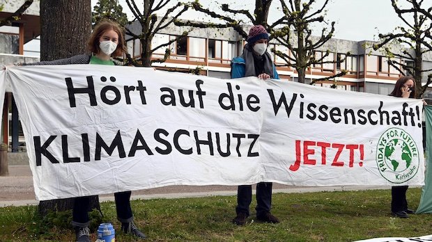 Mitglieder der Karlsruher Gruppe von Fridays for Future halten vor dem Bundesverfassungsgericht ein Transparent auf dem steht "Hört auf die Wissenschaft! Klimaschutz jetzt!".