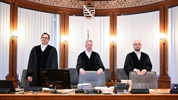 Das Leipziger Dienstgericht für Richter, unter Vorsitz von Hanns-Christian John (M), steht vor Prozessbeginn im Verhandlungssaal des Landgerichts Leipzig.