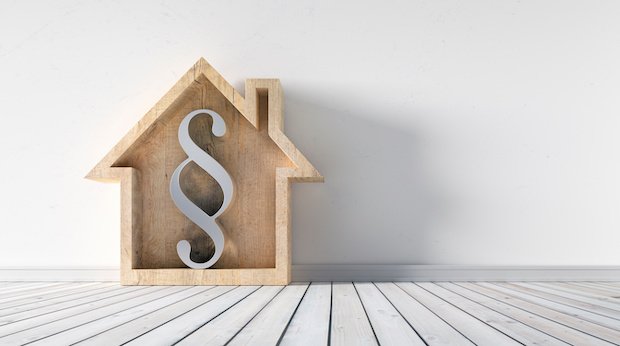 Symbolbild Immobilienrecht: Paragraphenzeichen in einem Holzhäuschen