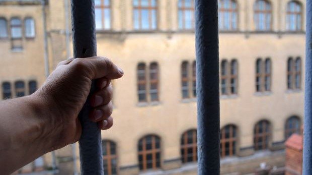 Mann hält sich im Gefängnis am Gitterfenster fest