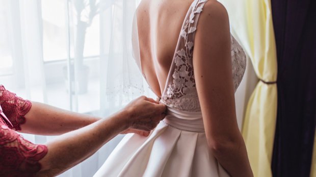Braut bei der Anprobe ihres Brautkleides