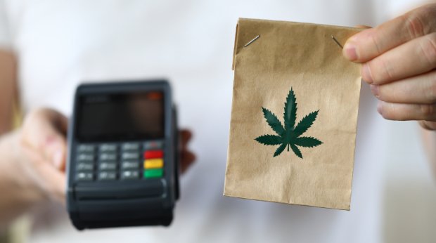 Eine Tüte mit einem Cannabisblatt und ein Kartenlesegerät
