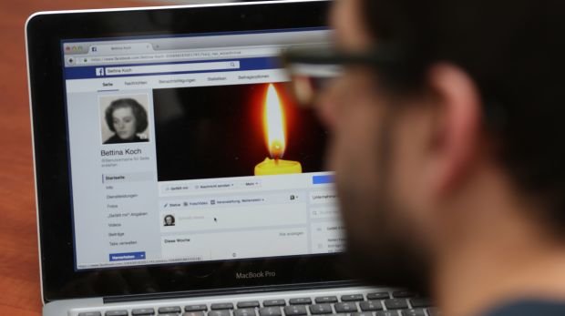 Mann vor Facebook-Profil im Gedenkzustand (Symbolbild)