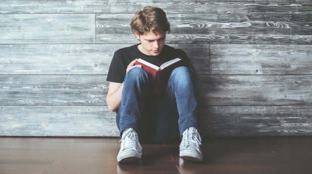 Jugendlicher liest ein Buch (Symbolbild)