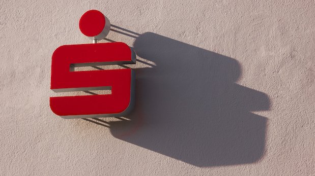 Ein Logo der Sparkasse wirft einen Schatten auf eine Hauswand
