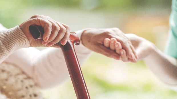 Pfleger hält altem Menschen die Hand