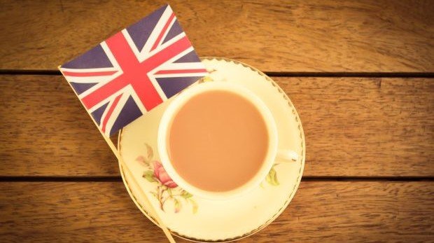 Tasse Tee und Union Jack auf Holztisch