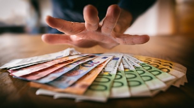 Hand greift nach Euro-Banknoten (Symbolbild)