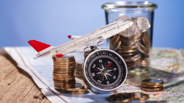 Modellflugzeug mit Kompass auf Geldmünzen