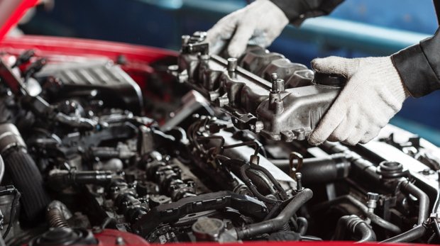 Mechaniker untersucht Motor eines Autos