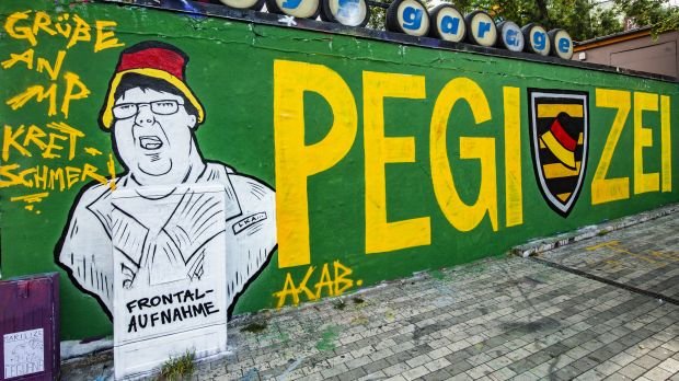 Ein Graffiti mit der Aufschrift "Pegizei" ist an einer Hauswand in der Dresdner Neustadt zu sehen. Thematisiert ist der umstrittene Polizeieinsatz gegen ein ZDF-Team am Rande einer Pegida-Demonstration gegen den Besuch von Kanzlerin Merkel.