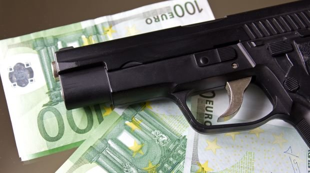 Pistole liegt auf Geldscheinen