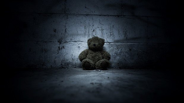 Teddybär in dunkler Ecke