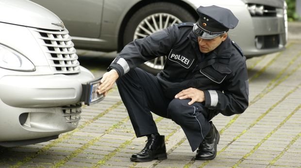 Polizist begutachtet Nummernschild (Symbolbild)