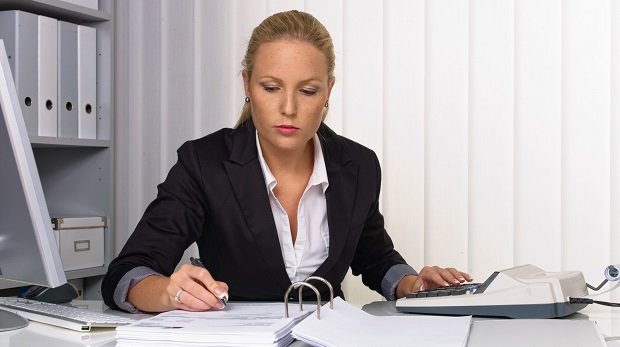 Eine Frau am Schreibtisch kalkuliert (Symbolbild)