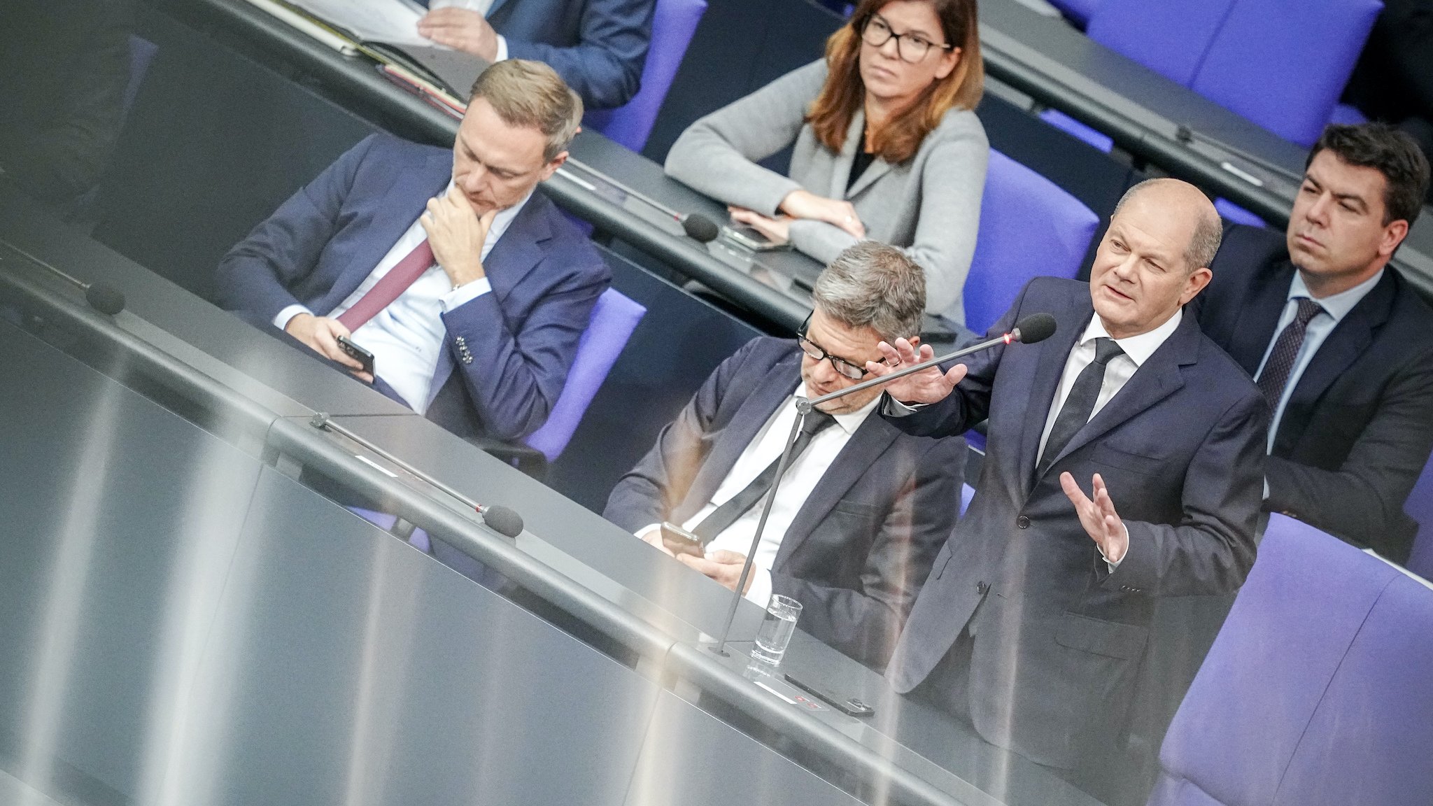 Bundeskanzler Scholz (SPD) spricht bei der Regierungsbefragung im Bundestag neben Christian Lindner (l, FDP) und Robert Habeck (Bündnis 90/Die Grünen) zu den Abgeordneten.