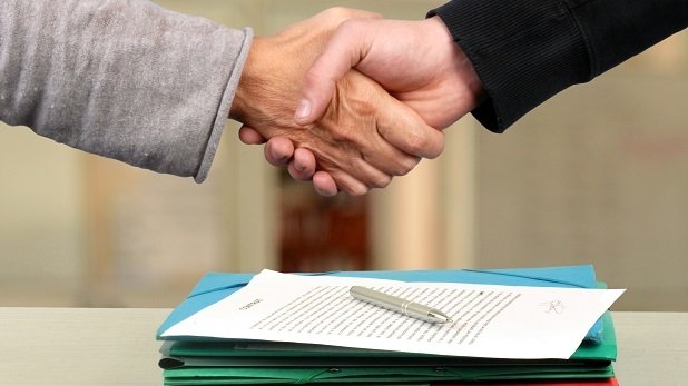 Handschlag über einem Vertrag