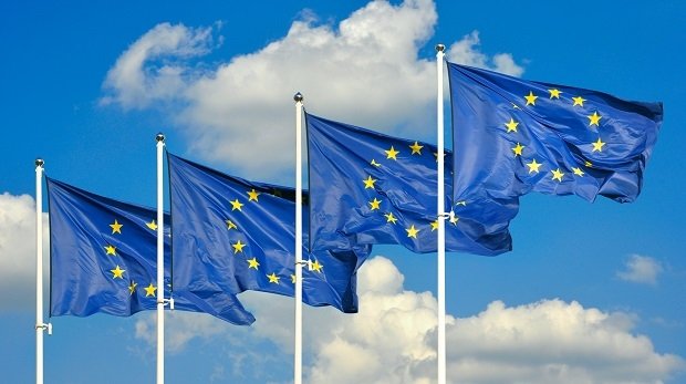 Flaggen der EU vor blauem Himmel.