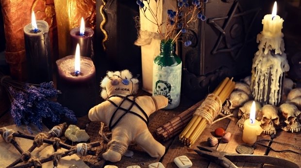 Voodoo-Puppe, Pentagram und schwarze Kerzen