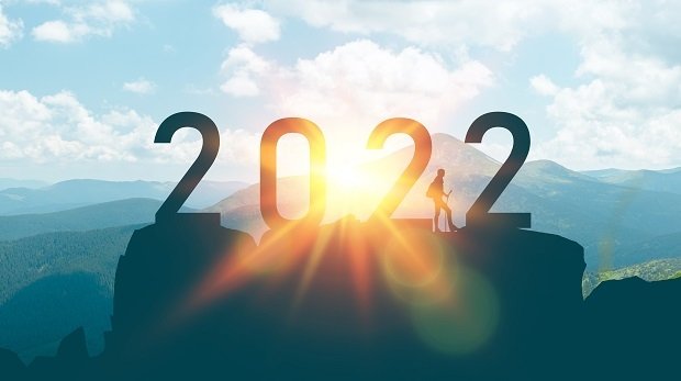 Ein Mann steht auf der Spitze eines Berges mit der Aufschrift "2022"