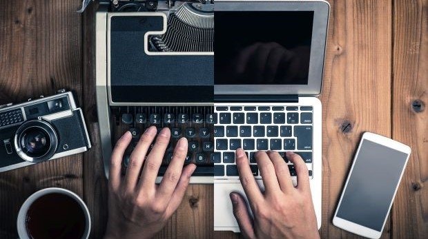 Schreibmaschine und alte Kamera links, Laptop und Smartphone rechts
