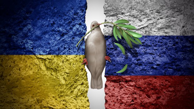 Friedenstaube mit Ölzweig zwischen steinernen Flaggen der Ukraine und Russland