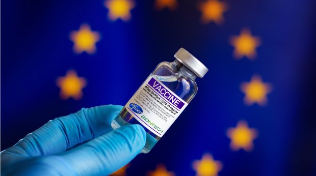 Covid-19-Impfstoff vor einer Europäischen Flagge