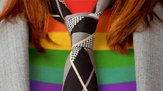 Frau mit Krawatte und Regenbogenpullover